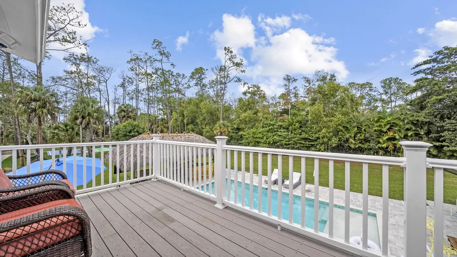 Upstairs balcony seating overlooking the pool and wooded backyard, The Naples Retreat, Naples FL