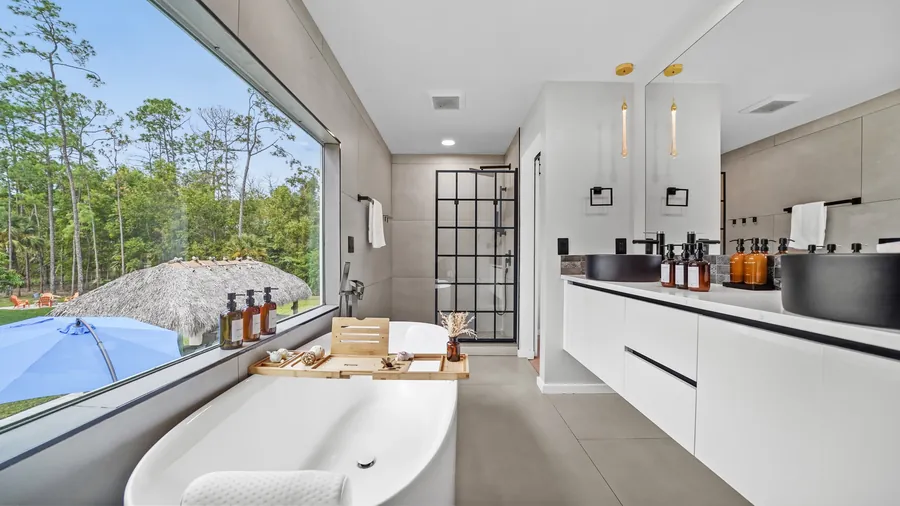 Primary bath with freestanding soaking tub, picture window and double vanity, The Naples Retreat, Naples FL