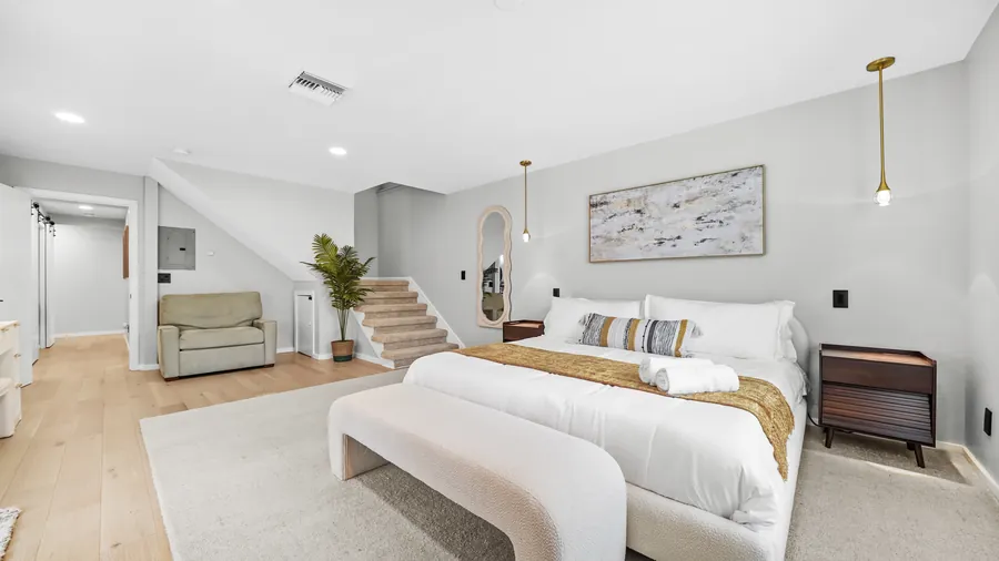 Primary king suite with bench, reading chair and stairs to the upper level, The Naples Retreat, Naples FL