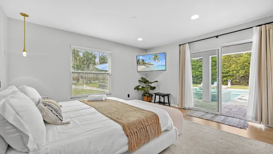 Primary suite with sliders opening directly onto the pool deck, The Naples Retreat, Naples FL