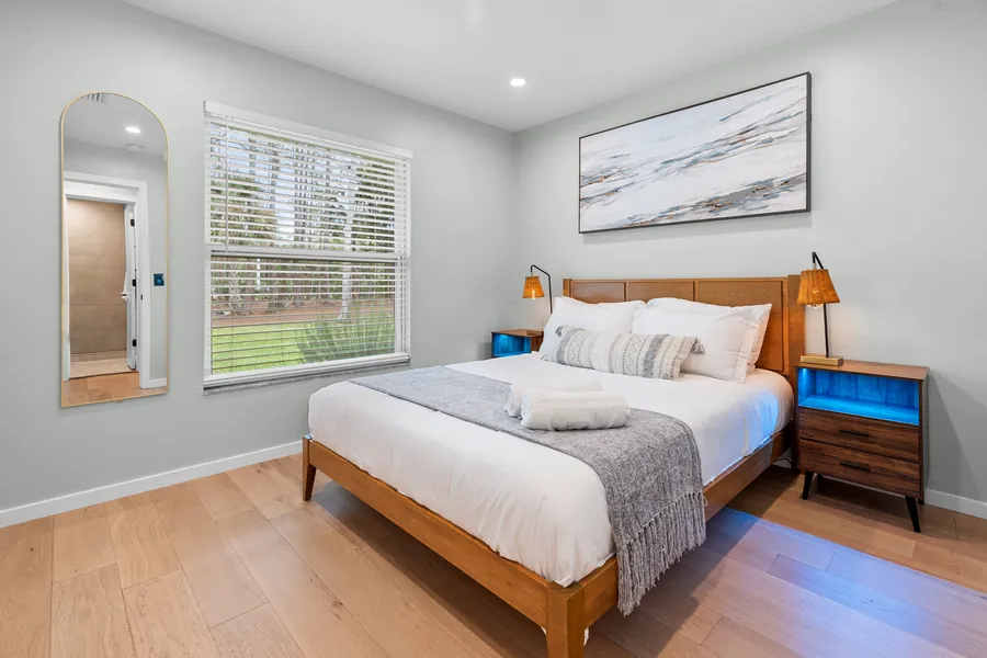 Queen bedroom with wood bed, bedside lamps and garden window, The Naples Retreat, Naples FL