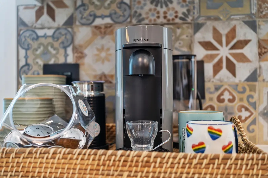 Coffee station with Nespresso machine, mugs and pods on the kitchen counter, The Naples Retreat, Naples FL
