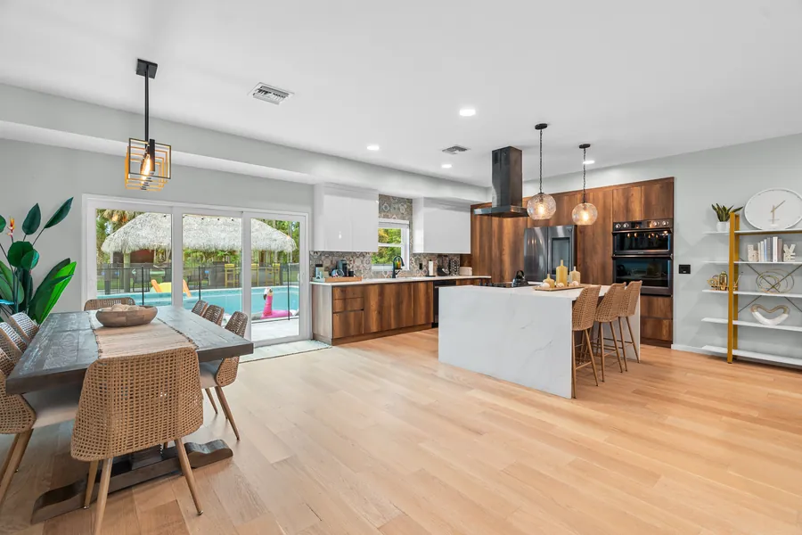 Open-plan dining and kitchen with sliders to the pool and tiki, The Naples Retreat, Naples FL