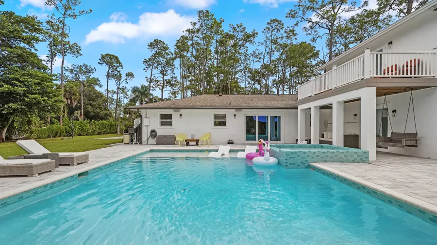 Saltwater pool and spa looking back to the house and covered patio swing, The Naples Retreat, Naples FL