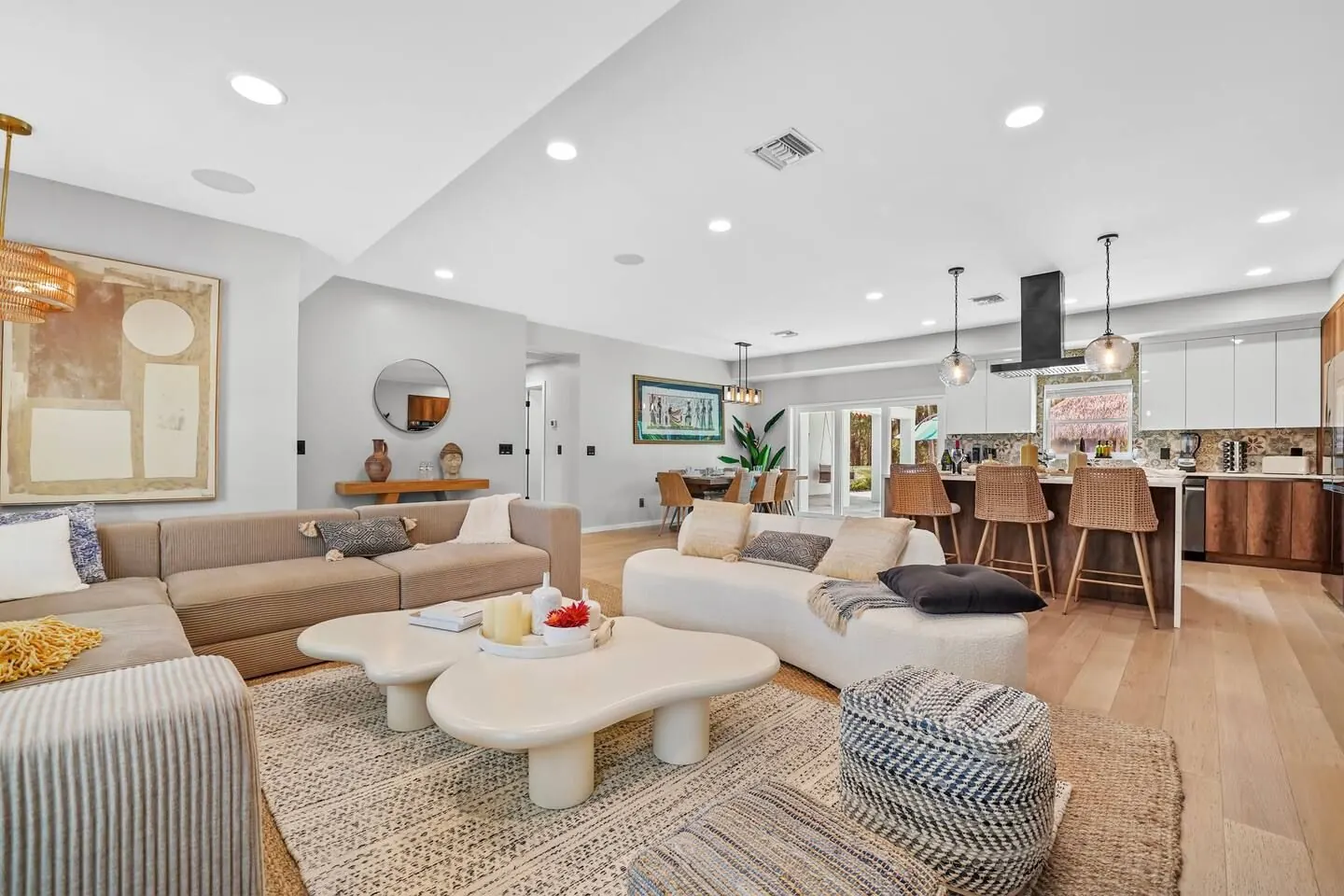Living room with a large sectional, coffee tables and plants