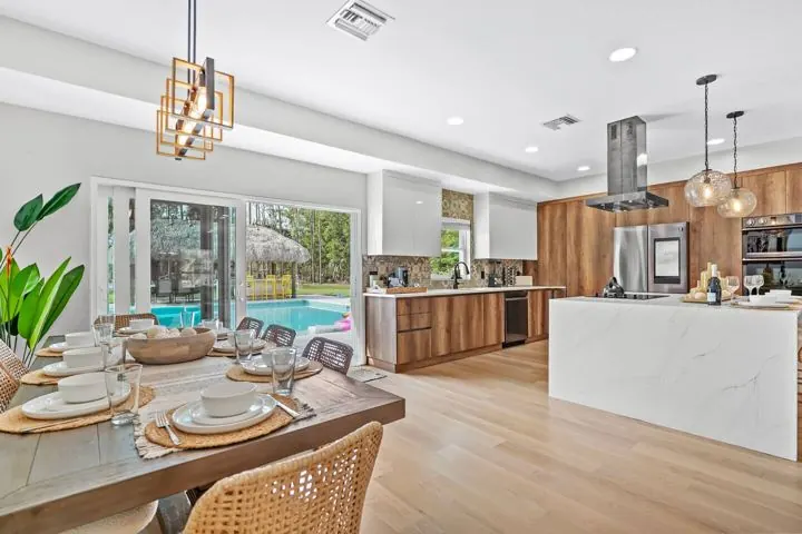 Kitchen island set for dinner with a pool view