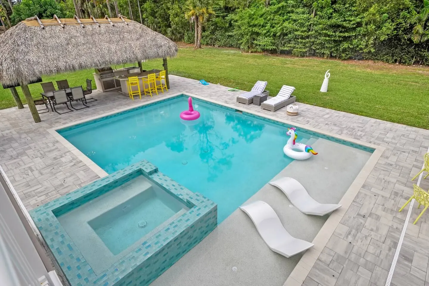 Saltwater pool with raised spa, in-water loungers and the tiki cabana