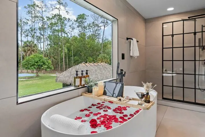 Soaking tub beside a picture window onto the pines