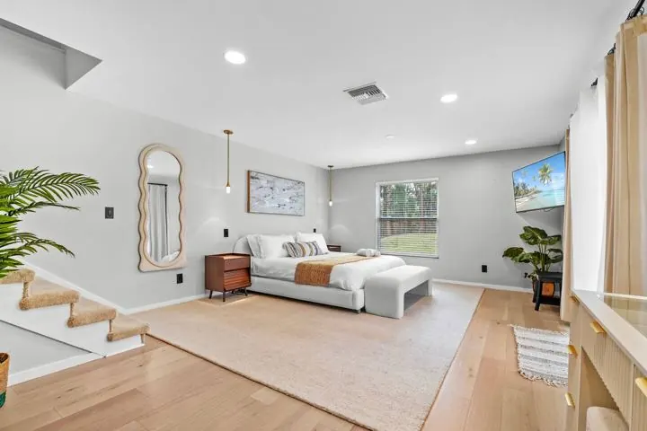 Primary bedroom with mirror and plants
